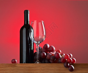 红色背景中的葡萄和红酒图片