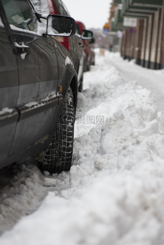 停在满是雪的街道上的汽车图片