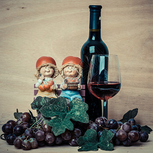 红酒和葡萄瓶装在木本底的红酒和葡萄上图片