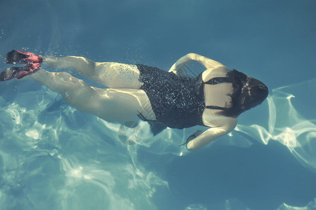 女人在游泳池里游泳图片