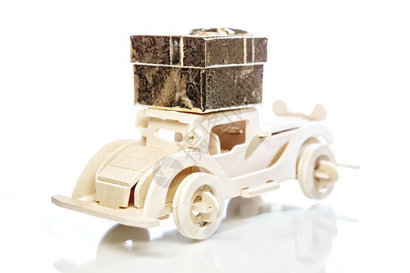 旧玩具老式木制汽车和礼品盒与白色背景上的反射选择地关注背景图片