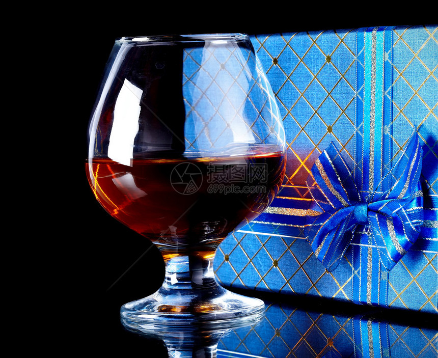 玻璃与酒精和一份礼物酒和礼品盒带弓的盒子和带图片
