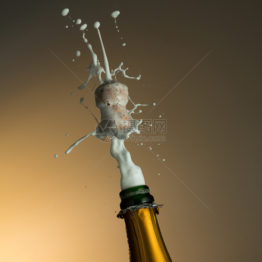一瓶香槟为新年晚宴盛开花在演播室拍图片