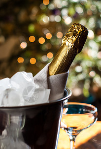 豪华的节日成份冰桶里一瓶冷香槟和餐巾纸图片