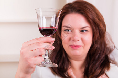 拿着一杯红酒的丰满开朗的女人背景图片