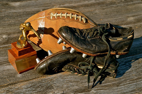 复古的奖杯足球和带钉鞋的子提供了对五六十年代足背景图片