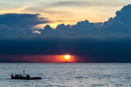 日落的美丽景象与多彩云的天空和海上船图片