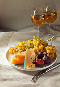 厨房桌上的奶酪水果和甜酒图片