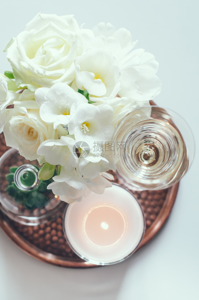 花瓶蜡烛和香槟的白色花束图片