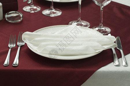 餐厅里配有眼镜餐盘和餐巾纸的喜宴桌背景图片