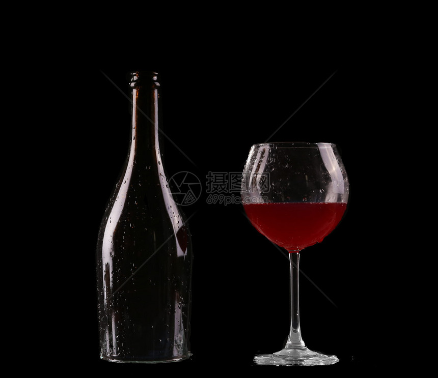 优雅的红葡萄酒杯和黑色背景中的酒瓶图片