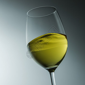 葡萄酒厂的一杯白葡萄酒在梯度背景上摇摆着图片