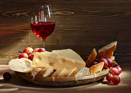 木桌上的奶酪面包和红酒图片