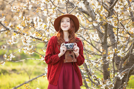 一个穿着红色毛衣和帽子的漂亮红发女人的肖像图片
