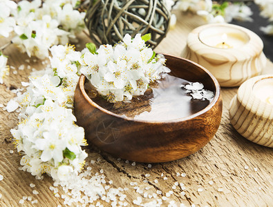 在木质背景上与木质水碗结合的白花粉健康与图片