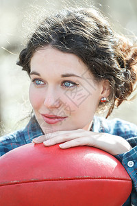 黑发蓝眼睛女孩与红色皮革足球的肖像图片