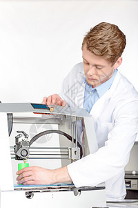 年轻英俊的科学家检查3D打印机绿色物品的模型图片