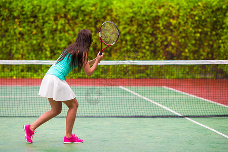 漂亮的女运动员在网球场上打球拍图片