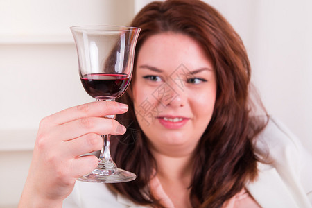 丰满优雅的女人喝着红酒图片