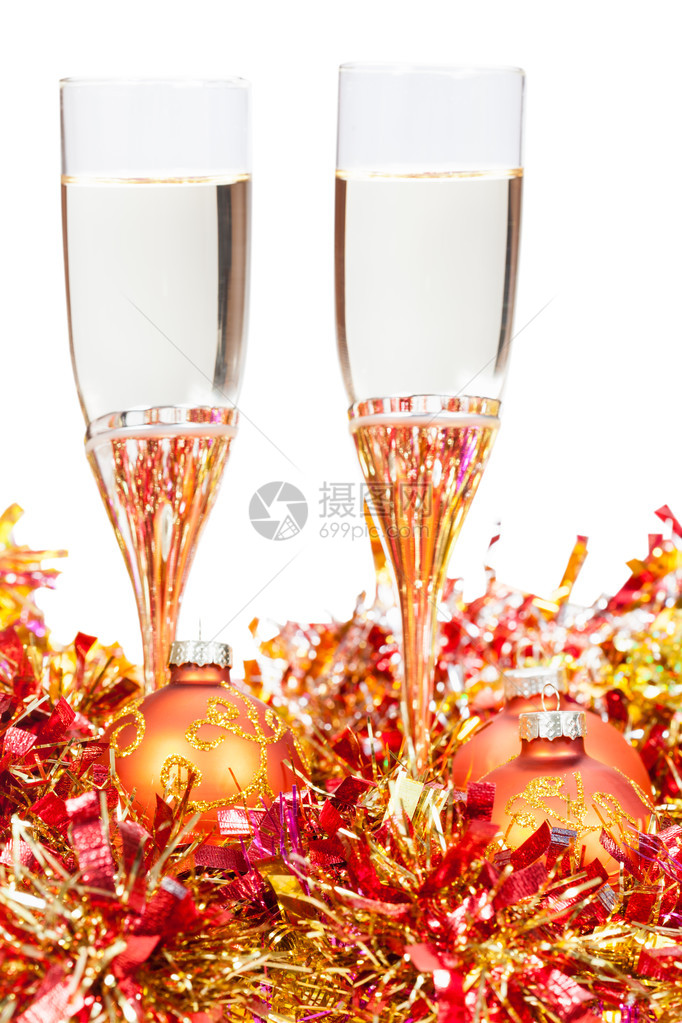两杯香槟在黄色和金黄色的圣诞节装饰品上白底隔图片