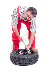 疲累的机械技工换新轮胎用在白色图片