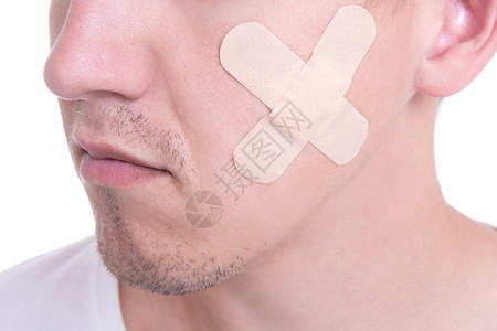 男脸颊医用胶布的特写图片