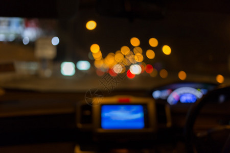 驾驶员在夜间路上以轻型交通看车内汽车的图片