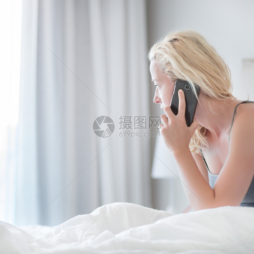 在家里的床上用手机的年轻女士的画像疲倦困的女人一大早就在床上图片