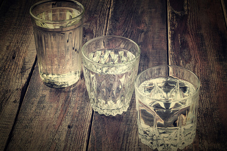 三种旧玻璃刻面玻璃与木桌上的水混杂旧刻面玻璃与图片