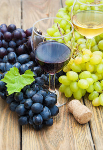 一杯酒和木桌上的葡萄图片