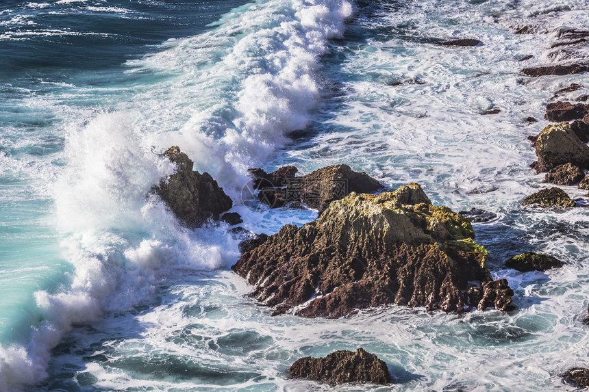 海中的风暴在狂野的岩石旁边图片