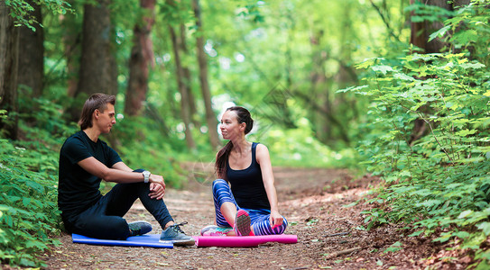 年轻健身活跃夫妇在公园外面做伸展图片