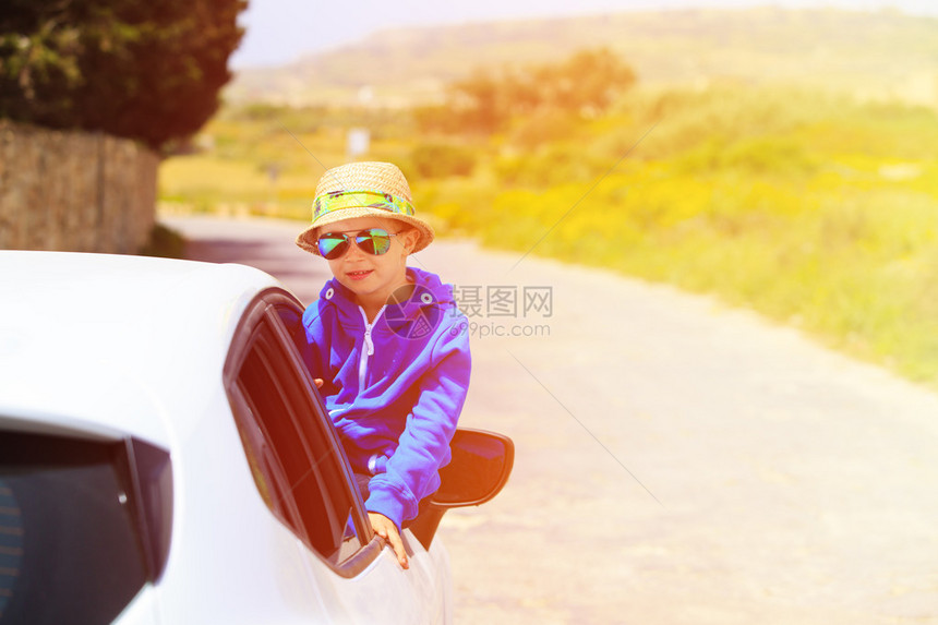 快乐的小男孩在路上乘车旅图片