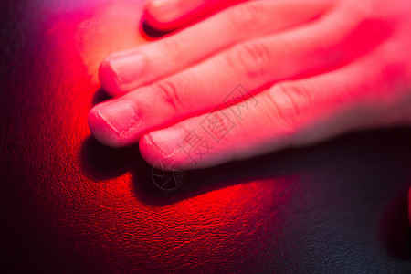 患者手在热光下进行红色理疗热处理背景图片