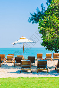在海滩上豪华酒店泳池度假胜地的伞型游泳池和椅子图片