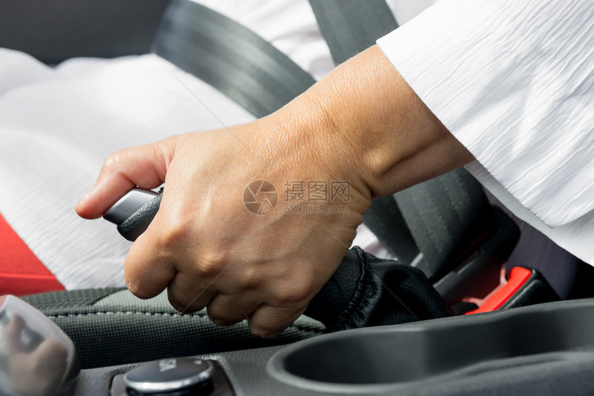 女人的手和汽车特写的手刹图片