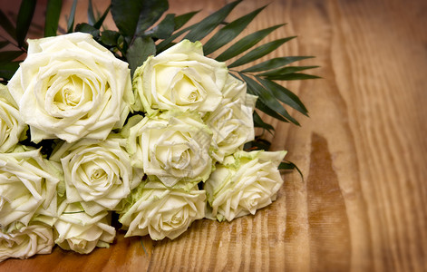 木桌上的三朵白玫瑰婚礼卡图片