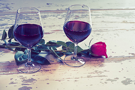 两杯红酒和一朵红玫瑰图片