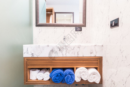 浴室内配有毛巾装饰的水龙头和水槽图片