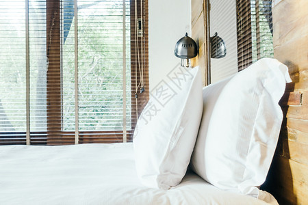 室内卧室轻光过滤器和选择焦点的床上装饰中的白图片