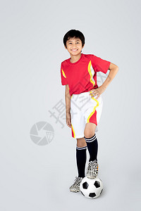 踢足球的可爱亚裔男孩灰色图片