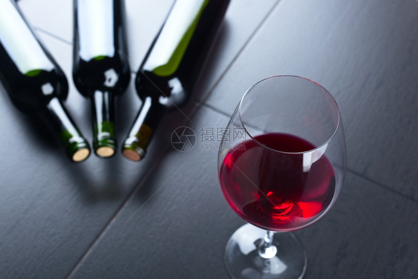 黑桌上的酒瓶和红酒杯图片