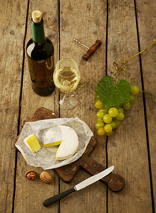 乡村背景中的白葡萄酒葡萄和奶酪图片