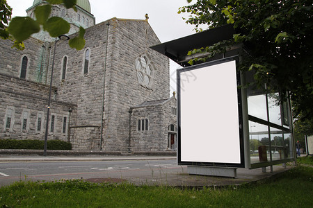 公共汽车站的空白广告牌背景是一座教堂图片