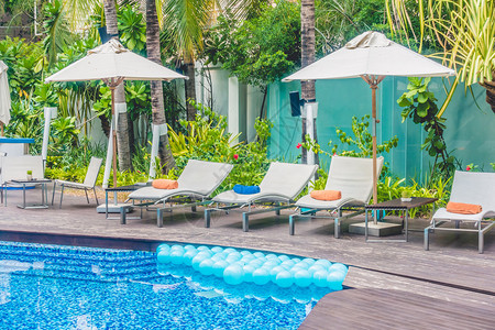 酒店度假村美丽的豪华游泳池周围的雨伞池和椅子复图片