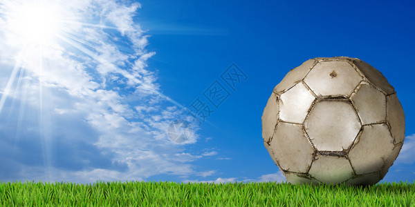 白足球橄榄球绿草和蓝天空有图片