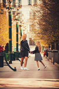 母亲和女儿在公园拉着手走路图片