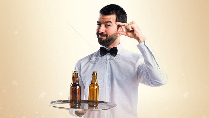 餐盘上装着啤酒瓶的服务员在图片