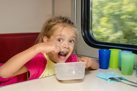 火车上的女孩坐在汽车二等舱车厢下层的一张桌子上图片