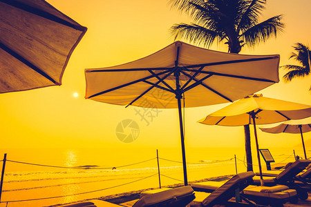 美丽的剪影豪华伞和椅子在酒店泳池度假村的游泳池周围图片